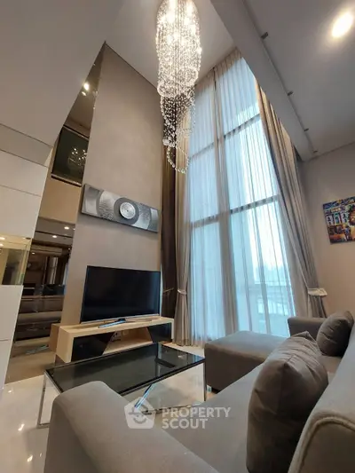 Luxurious high-ceiling living room with elegant chandelier and modern decor