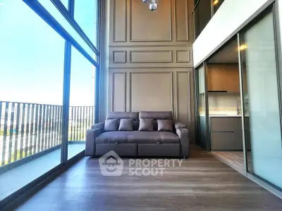Luxurious high-ceiling living room with floor-to-ceiling windows and modern sofa.