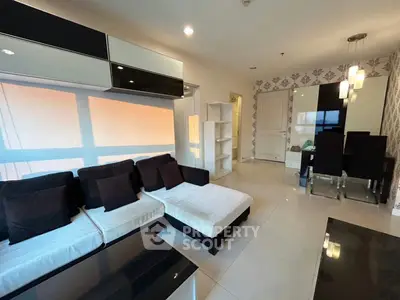 Modern living room with stylish furniture and elegant dining area, featuring chic decor and ample natural light.