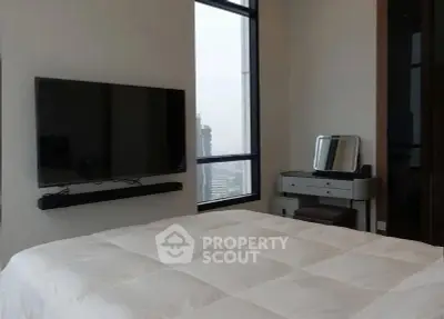 Modern bedroom with city view, wall-mounted TV, and sleek furniture.