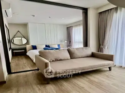 Modern bedroom with stylish decor and cozy sofa in a well-lit apartment.