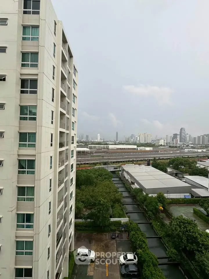 High-rise building with cityscape view and lush greenery, ideal urban living.