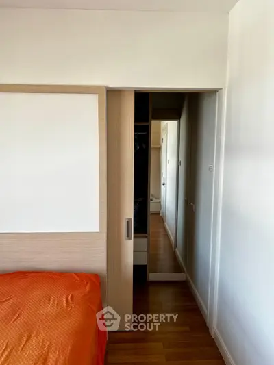 Modern bedroom with sliding closet door and vibrant orange bedding