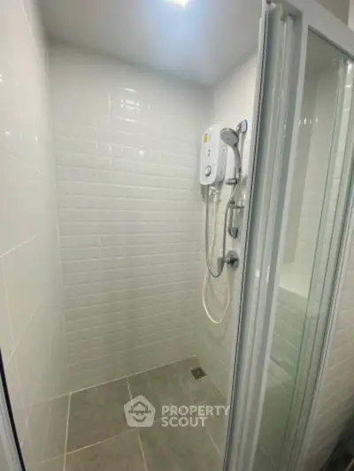 Modern bathroom shower with sleek white tiles and glass door enclosure