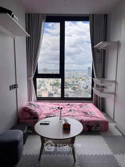 Cozy bedroom with stunning city view from large window, featuring minimalist decor and pink bedding.