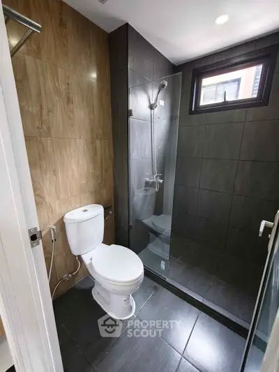 Modern bathroom with glass shower and wooden tile accents