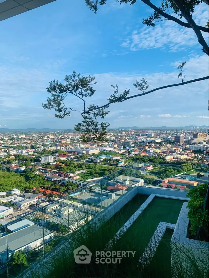 Stunning rooftop view of cityscape with lush greenery and clear blue sky, perfect for urban living.