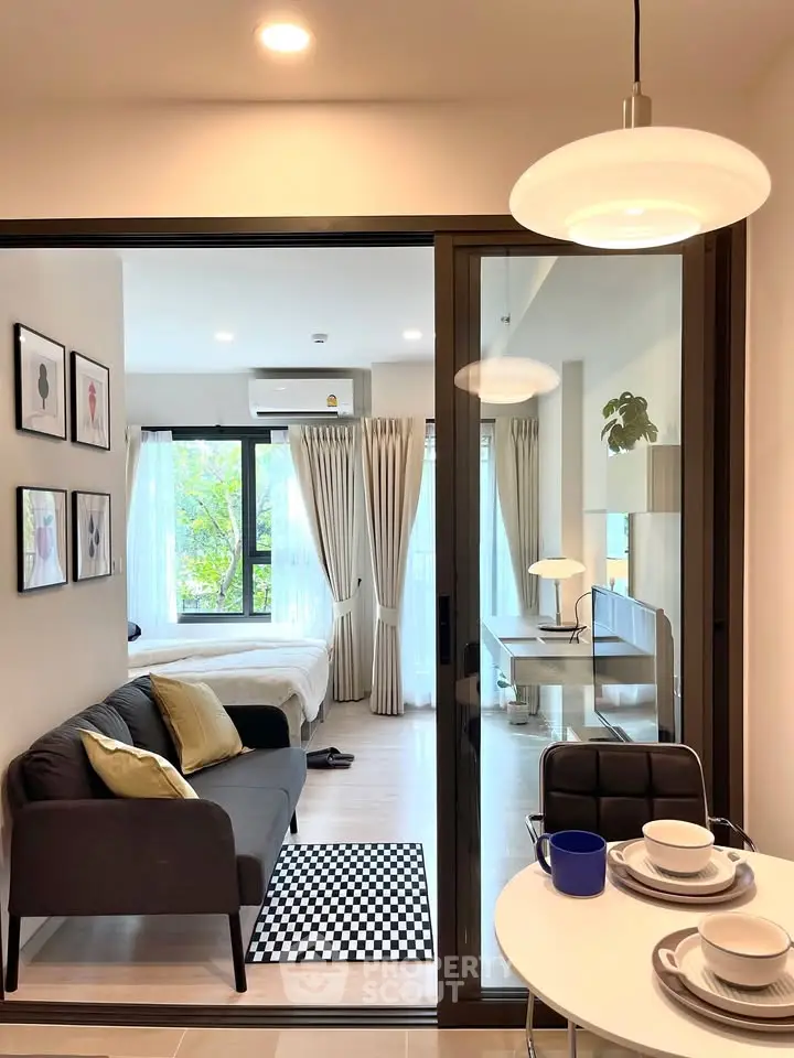 Modern open-plan living room with cozy sofa and dining area, featuring stylish decor and natural light.
