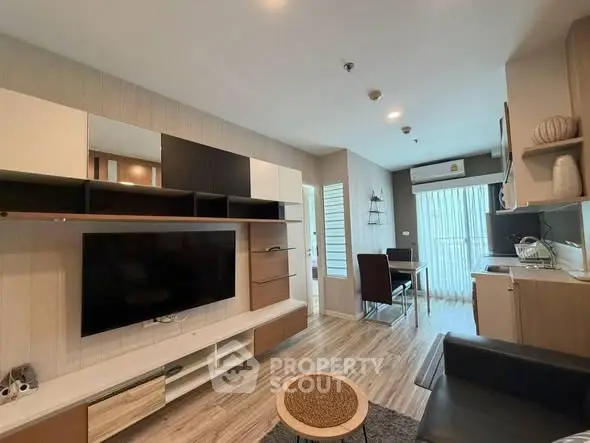 Modern living room with stylish furniture and open layout, featuring a large TV and dining area.
