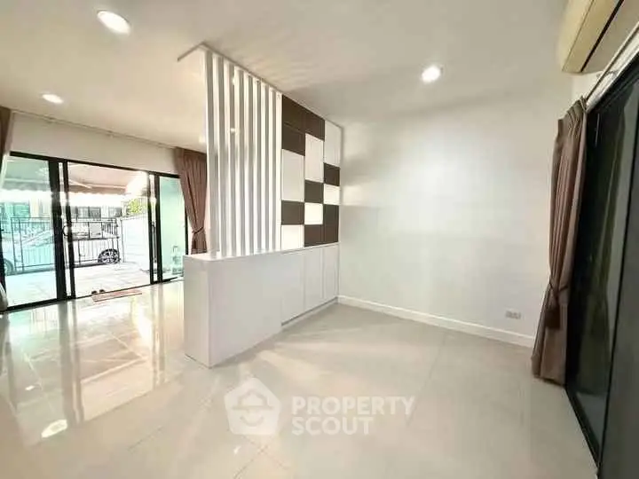 Spacious modern living room with large windows and stylish partition wall