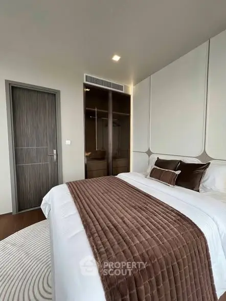 Luxurious bedroom with elegant decor and plush bedding in modern apartment.