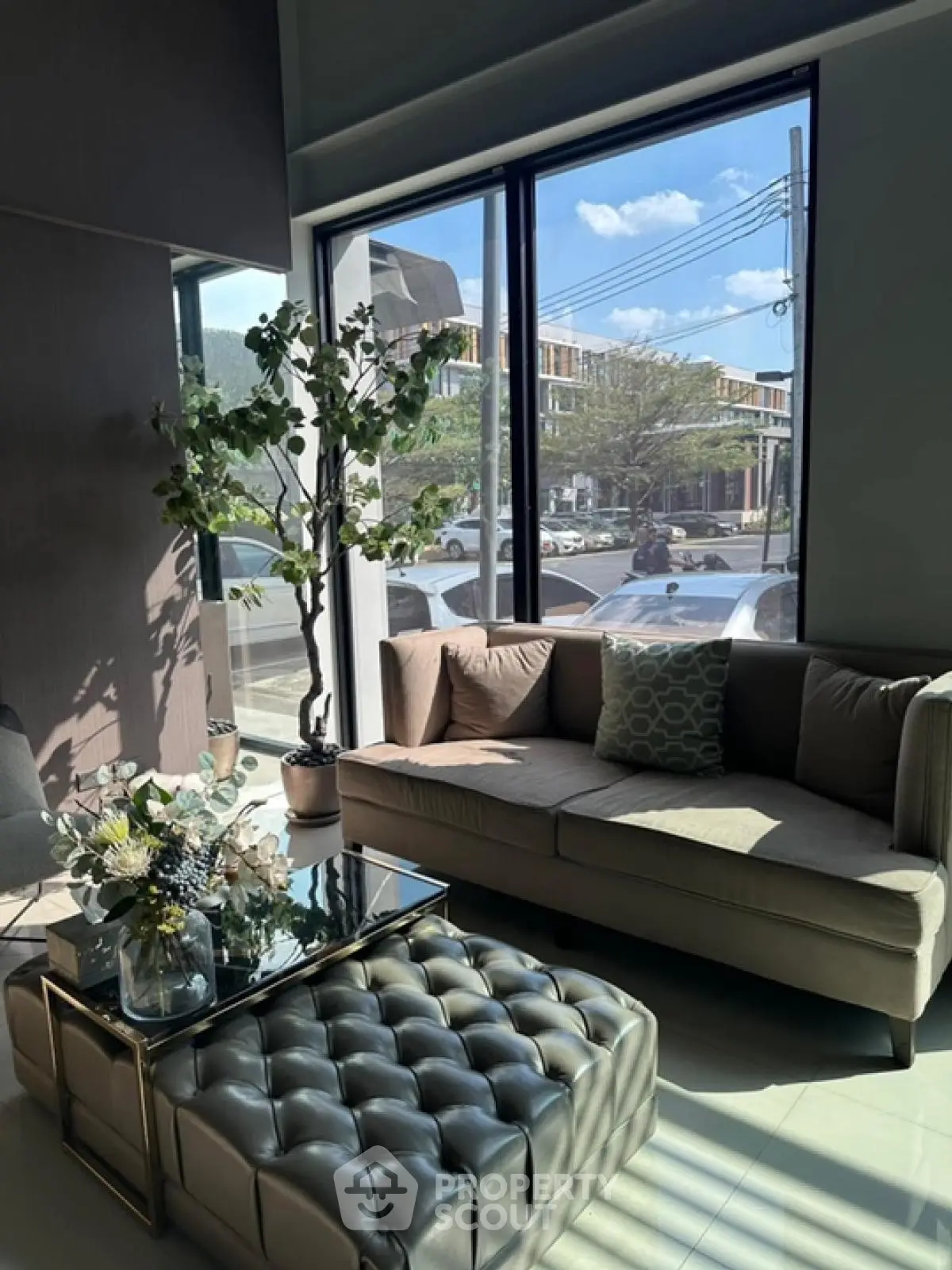 Modern living room with large windows and stylish furniture, offering a bright and inviting atmosphere.