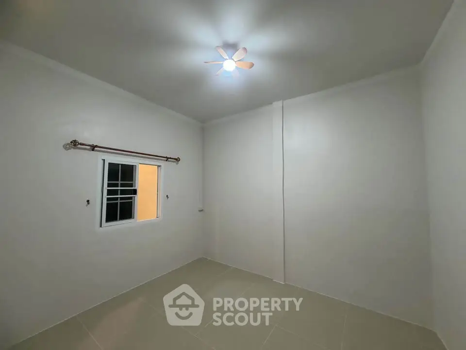Minimalist empty room with tiled floor and ceiling fan, ready for customization.