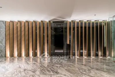 Luxurious modern elevator lobby with marble flooring and elegant wooden paneling.