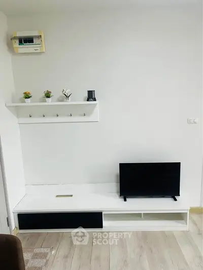Modern minimalist living room with sleek TV stand and decorative shelf, perfect for contemporary urban living.