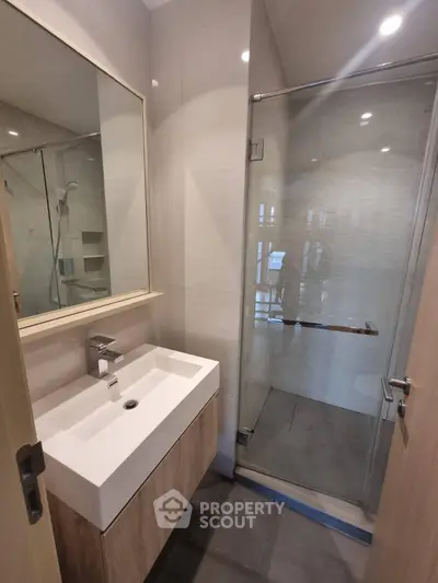 Modern bathroom with sleek vanity and glass shower enclosure