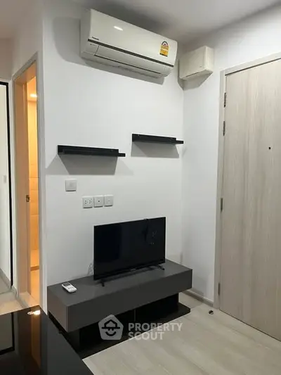 Modern living room with air conditioning and sleek TV setup in a stylish apartment.