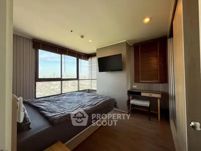 Modern bedroom with city view, featuring large windows and stylish decor in a high-rise apartment.