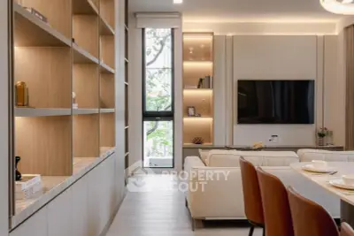 Modern living room with stylish shelving, large TV, and elegant dining area, perfect for contemporary living.