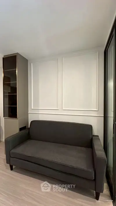 Modern living room with sleek gray sofa and elegant wall paneling