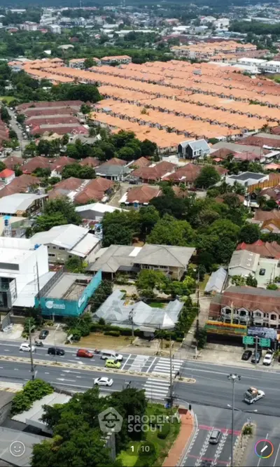 Aerial view of suburban neighborhood with rows of houses and lush greenery.