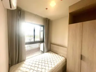 Cozy bedroom with natural light and modern furnishings in a stylish apartment.