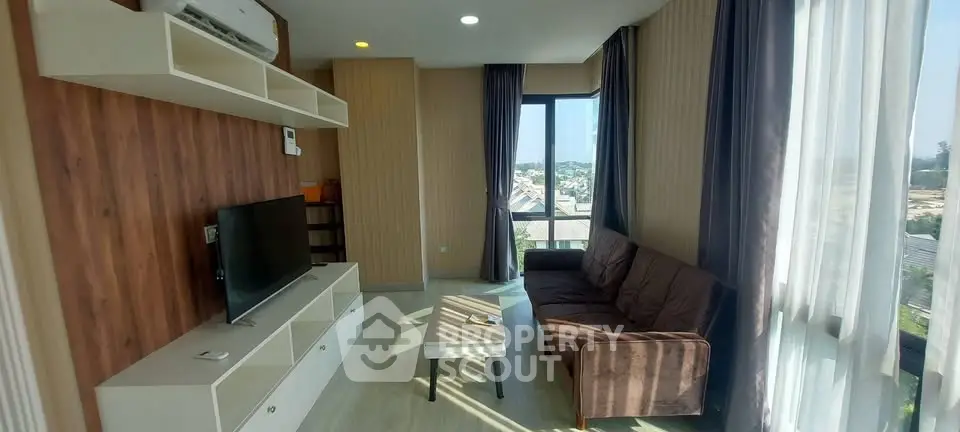 Bright living room with modern decor and large windows offering scenic views.