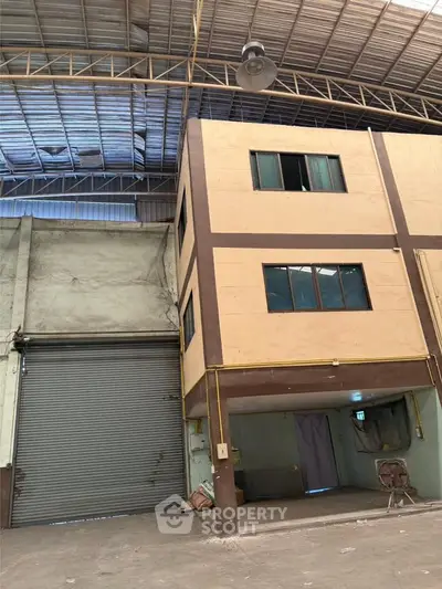 Spacious industrial warehouse with high ceilings and large roller door access.