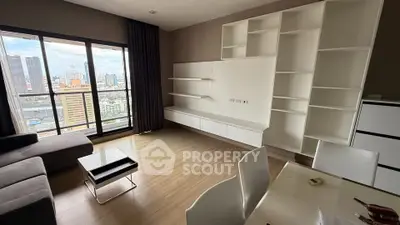 Modern living room with city view, featuring sleek furniture and large windows for natural light.