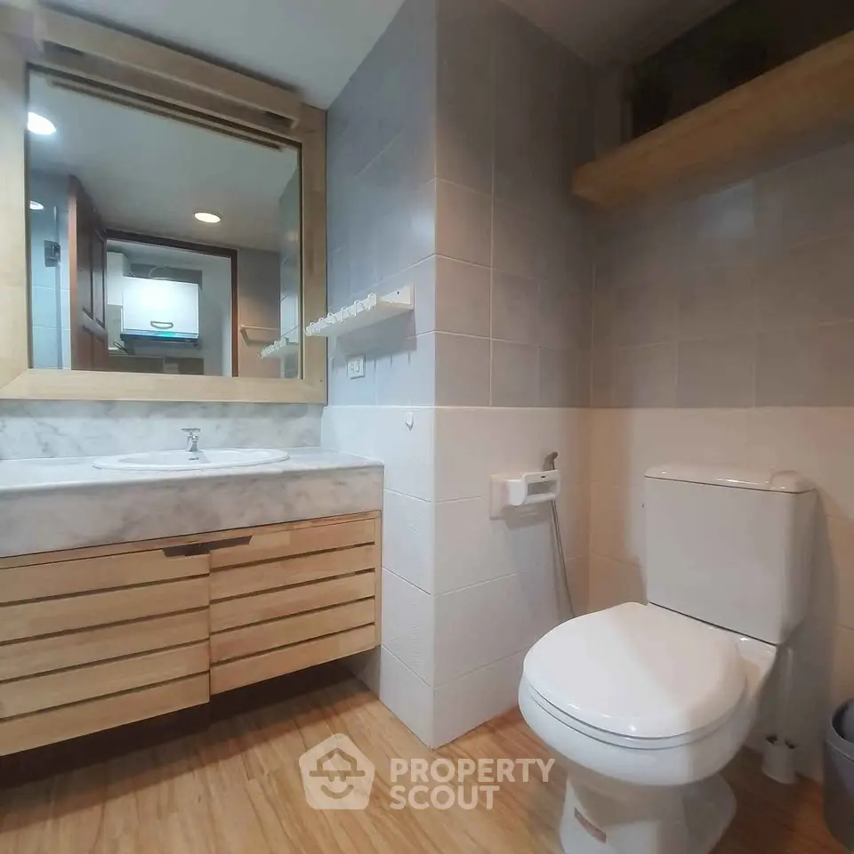 Modern bathroom with wooden accents and sleek fixtures in a stylish home.