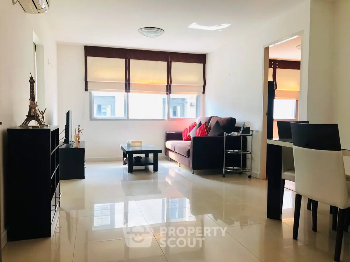 Bright and modern living room with sleek furniture and large windows in a stylish apartment.
