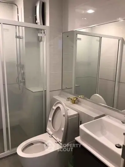 Modern bathroom with glass shower, sleek fixtures, and contemporary design.