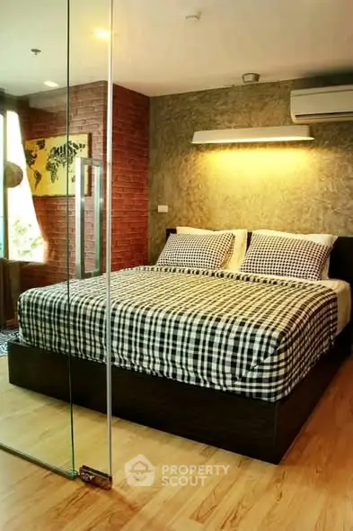 Modern bedroom with stylish decor and glass partition, featuring a cozy bed and ambient lighting.