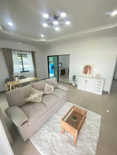 Spacious living room with modern decor and natural light, perfect for relaxation and entertaining.