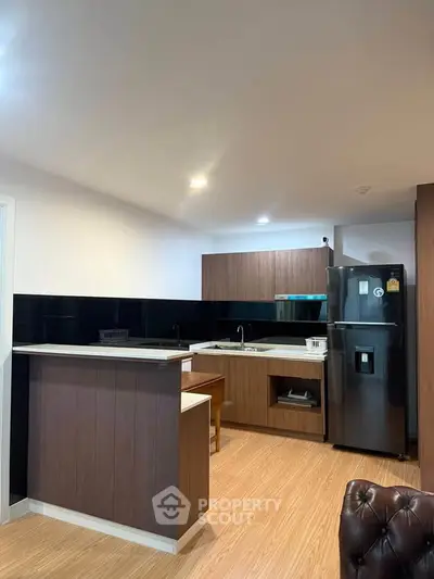 Modern kitchen with sleek cabinetry and black appliances in a stylish apartment.