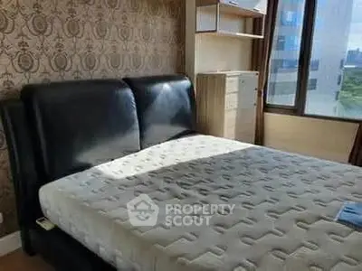 Spacious bedroom with modern decor and large window offering city views.