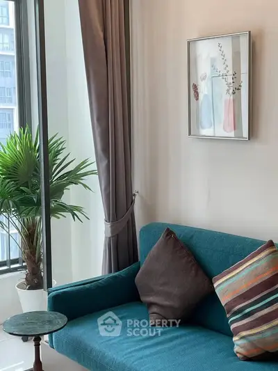 Chic living room with modern decor, featuring a teal sofa, stylish cushions, and a large window with city view.