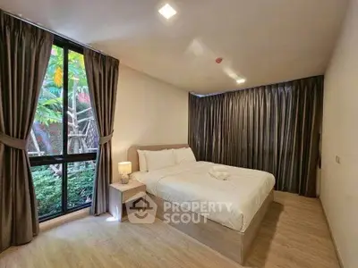 Spacious bedroom with large windows and elegant curtains in modern apartment