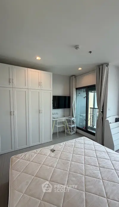 Modern bedroom with balcony access and built-in wardrobe in a stylish apartment.