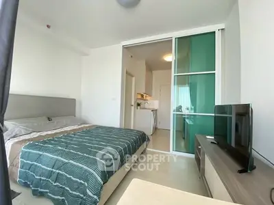 Modern bedroom with sliding glass doors and stylish decor in a contemporary apartment.