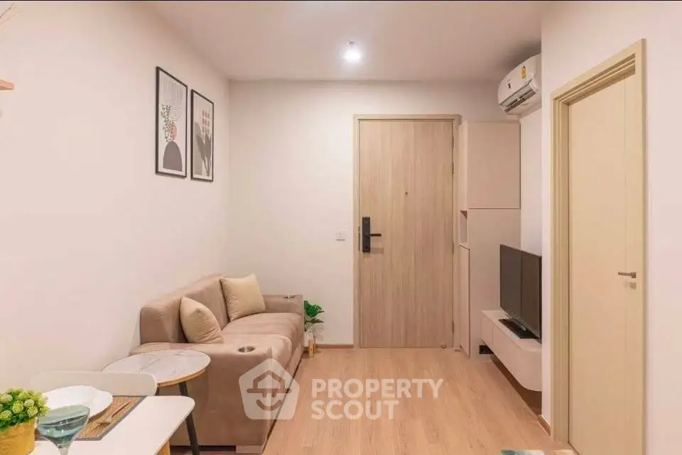 Cozy modern living room with stylish decor and neutral tones, featuring a comfortable sofa and wall-mounted TV.