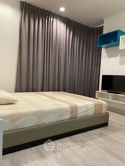 Cozy bedroom with modern decor and stylish curtains, perfect for relaxation.