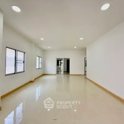 Spacious and bright empty room with large windows and glossy tiled floor, perfect for customization.