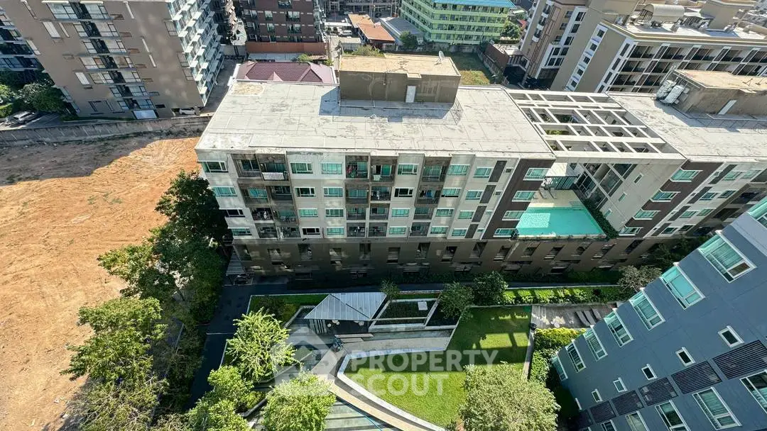 Aerial view of modern apartment complex with pool and garden