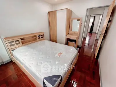 Cozy bedroom with wooden furniture and polished floor, perfect for relaxation.