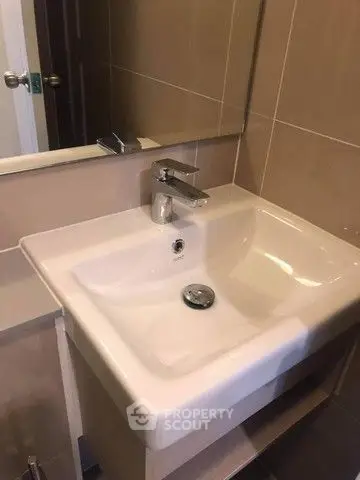 Modern bathroom with sleek sink and mirror in stylish apartment.