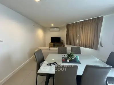Modern living room with dining area, featuring sleek furniture and neutral tones for a cozy ambiance.