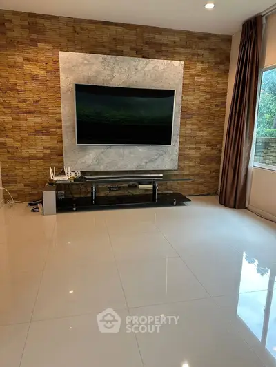 Modern living room with sleek TV setup and stylish brick accent wall