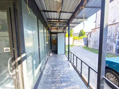 Spacious outdoor corridor with metal roofing and glass doors, ideal for commercial use.