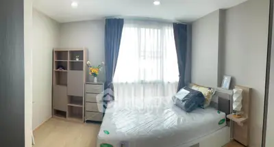 Cozy bedroom with natural light, modern furnishings, and elegant decor in a stylish apartment.